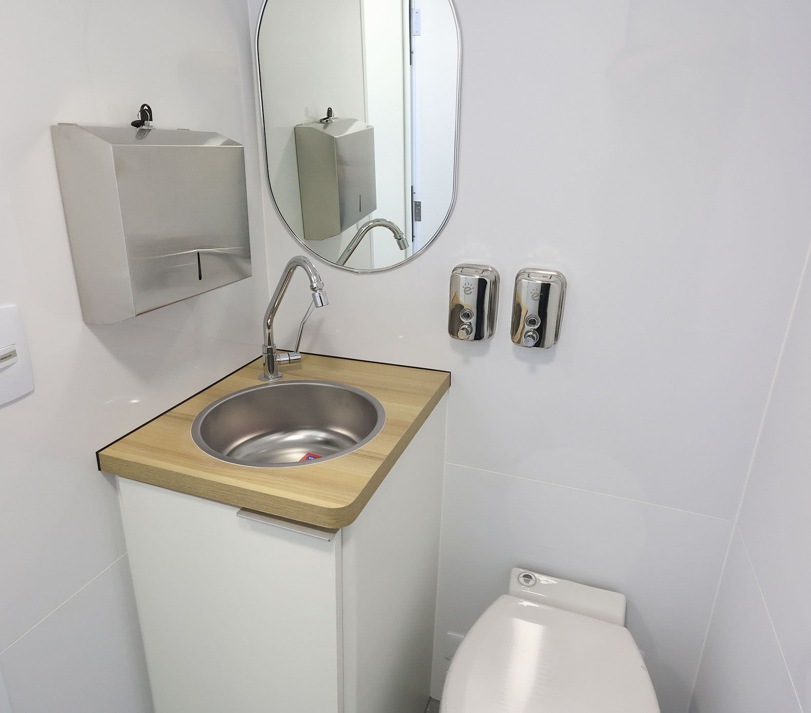 Compact bathroom in the mobile unit, with a sink, countertop, and accessories